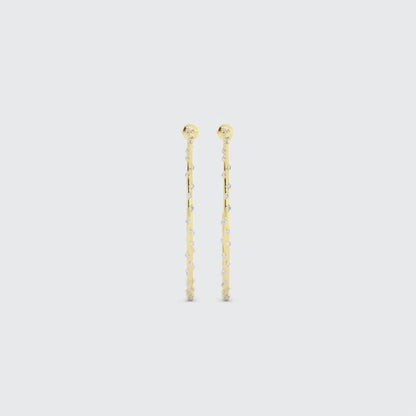 Video of long gold drop earrings with small embedded gemstones on a white background