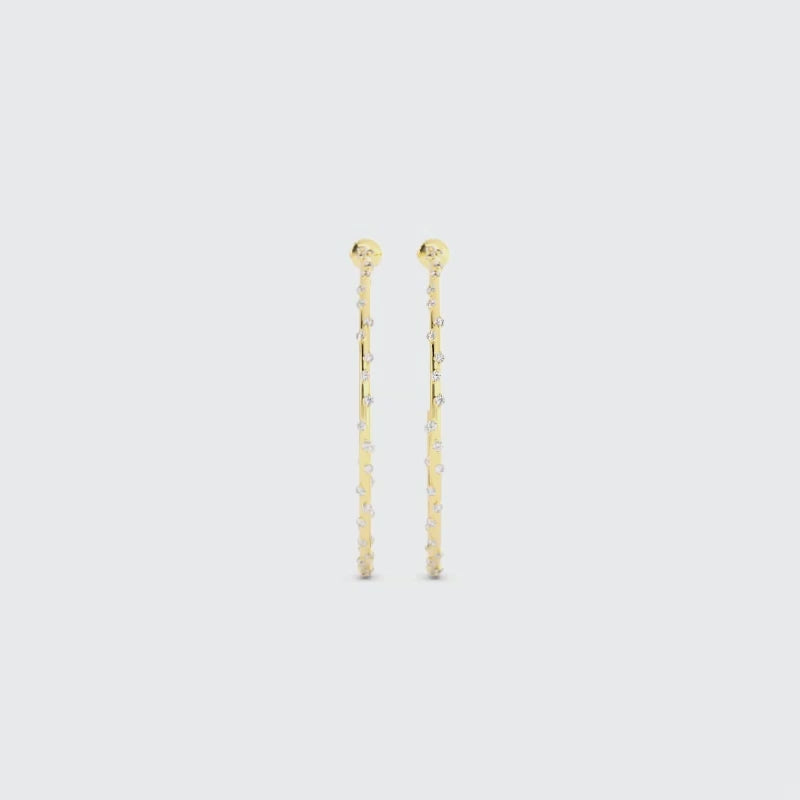 Video of long gold drop earrings with small embedded gemstones on a white background