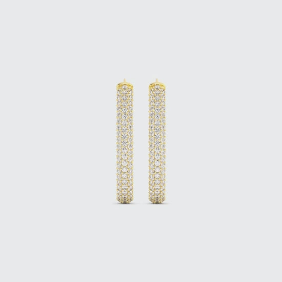 Video of gold drop earrings covered in pave diamonds on a white background